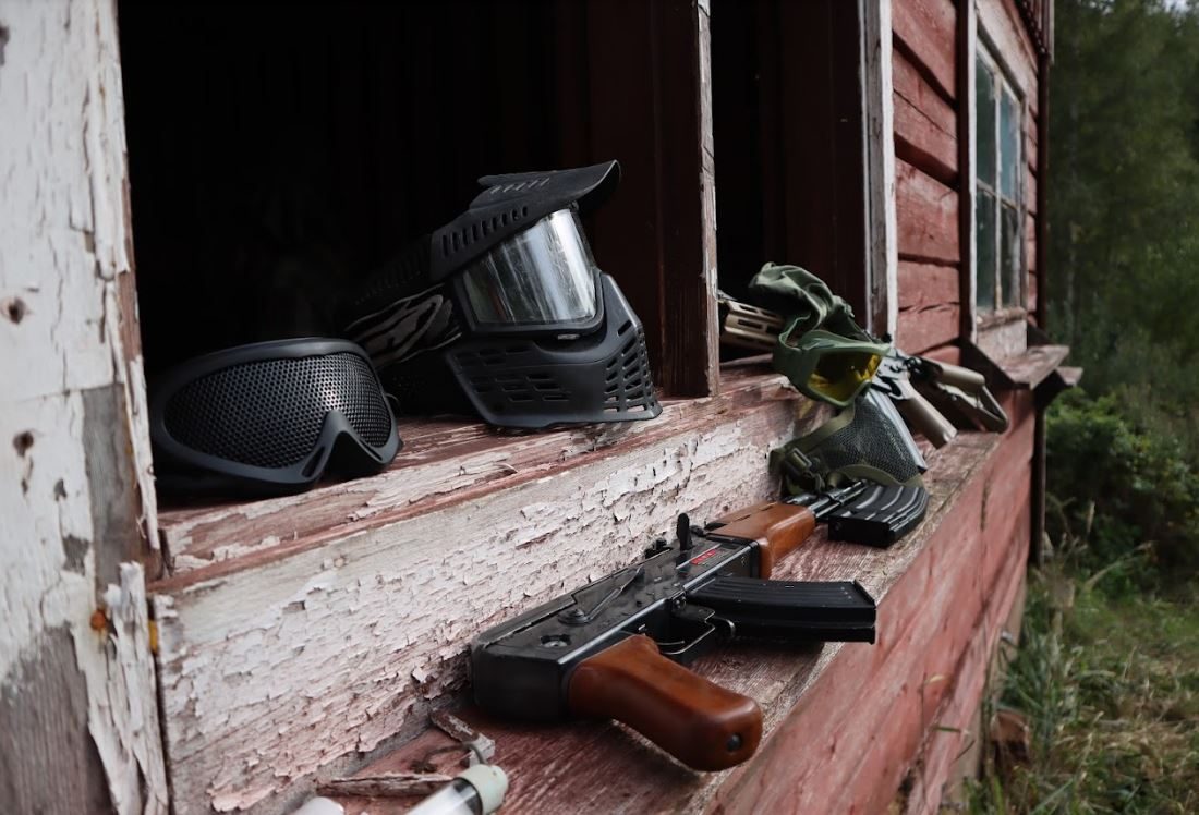 Airsoft-kasvosuojia ja replika vanhan puurakennuksen ikkunalaudalla Akaasoftin pelialueella